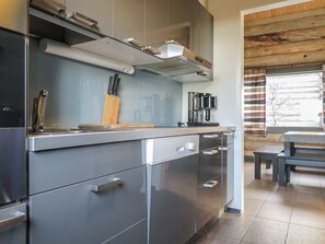 Une cuisine moderne équipée d’appareils électroménagers en acier inoxydable, d’un bloc à couteaux et d’une machine à café.