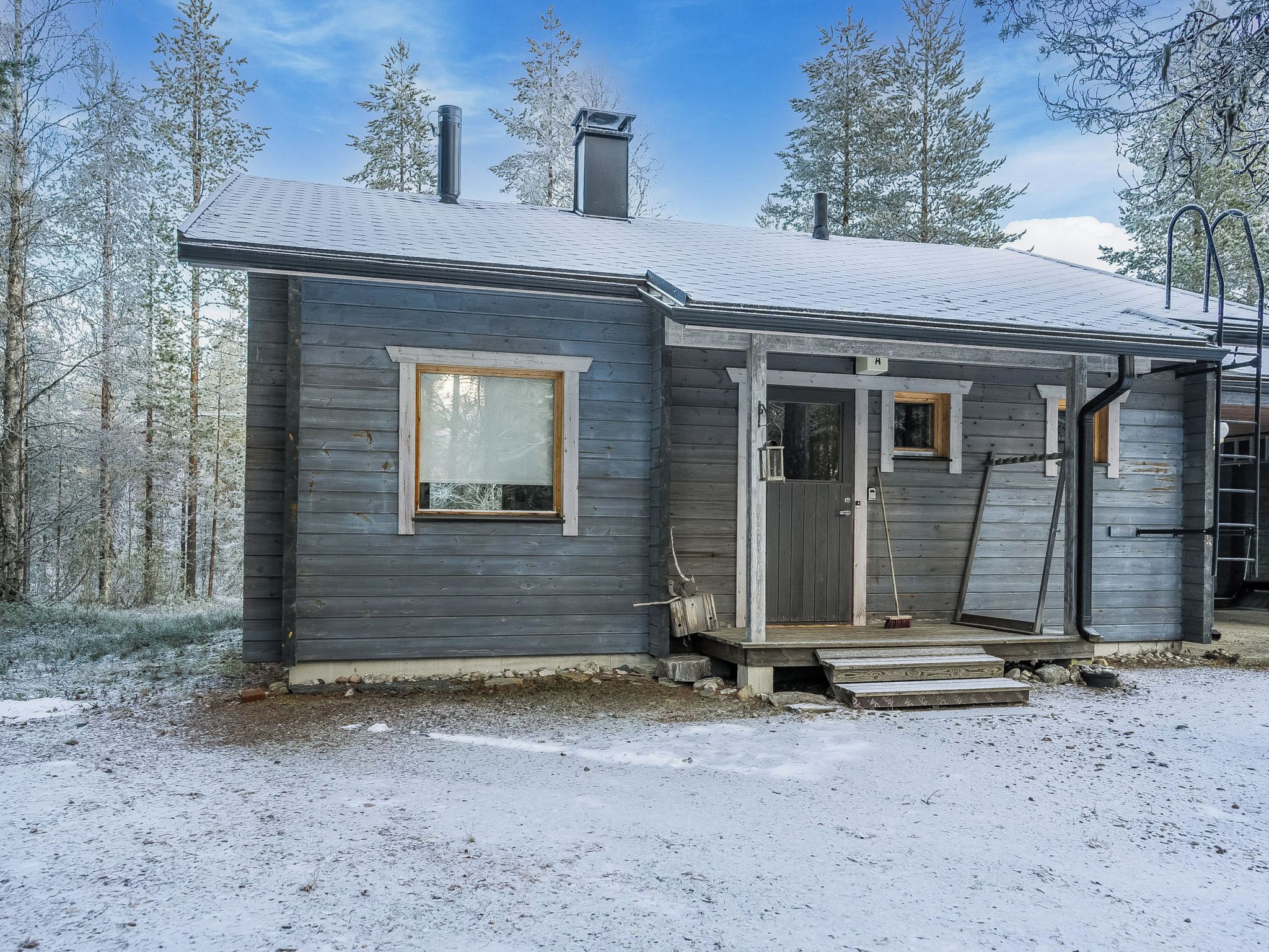 A small cabin with a front porch, a door, and a window.