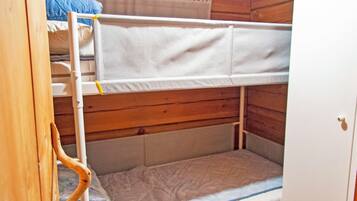 Un lit superposé avec une tête de lit en bois et un lit inférieur doté d’un matelas.