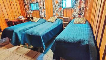 Une chambre avec deux lits, un bureau avec un ordinateur et une fenêtre avec des rideaux.