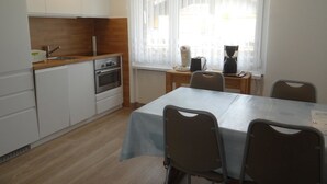 Una cocina compacta con un lavamanos, estufa y un reloj en la pared.