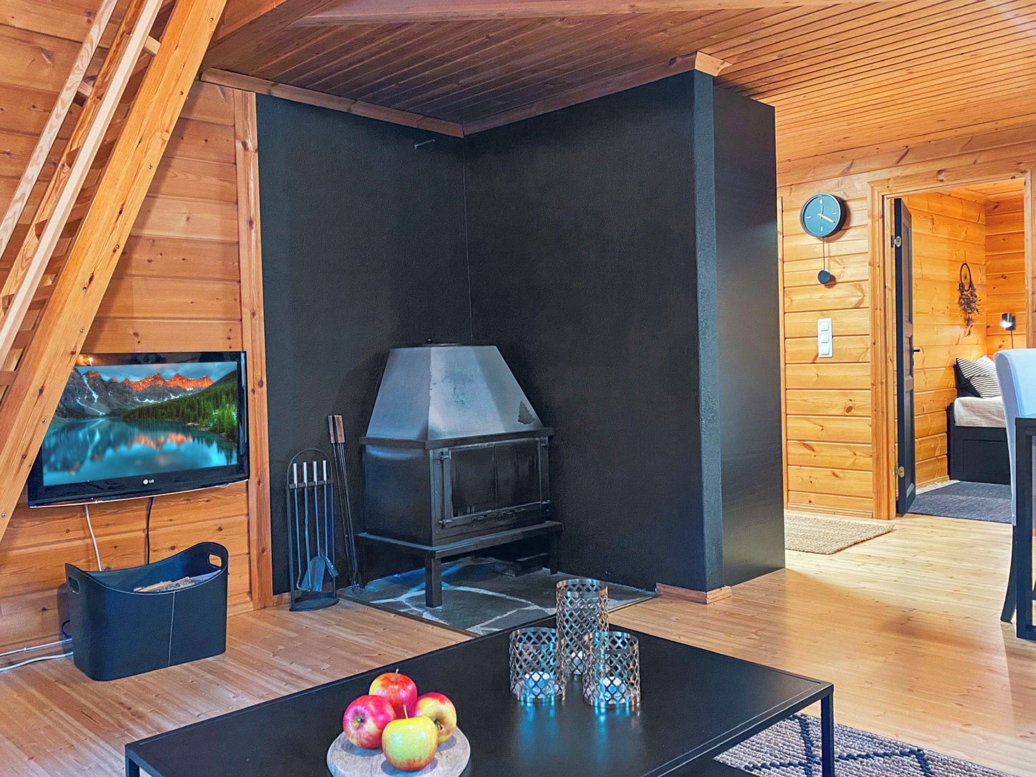 A modern living room with a fireplace, a television, and a dining area with fruit.