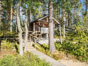 A cabin with a wooden deck and a staircase leading to a porch. - Mökinniemi by Interhome (Juva)