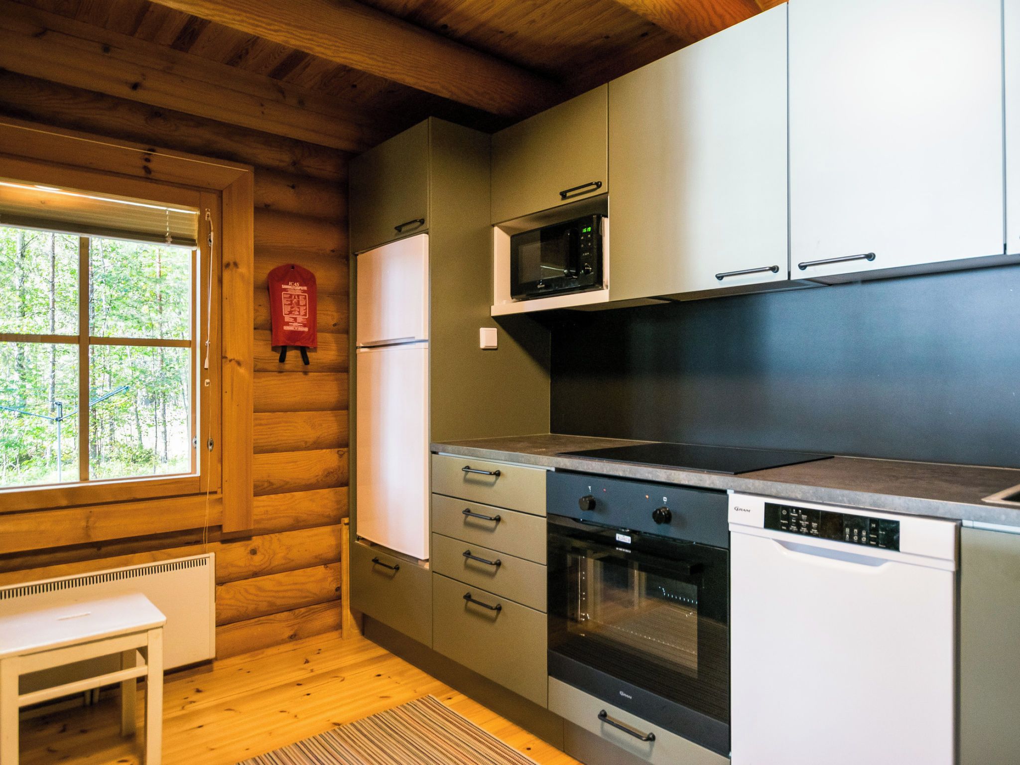 A compact kitchen with a refrigerator, microwave, oven, and dishwasher.