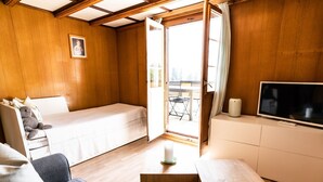 A cozy room with a bed, a sofa, a TV, and a small table. - Bürcher Haus 1. OG Süd-West by Interhome (Riederalp)