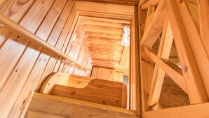 Un interior de madera con una escalera que sube a un nivel superior.