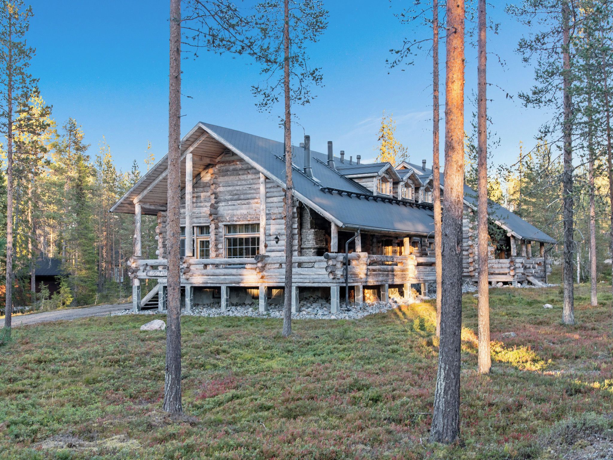 A log cabin with a sloped roof, multiple windows, and a deck area.