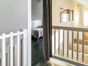 Un escalier menant à une chambre à coucher avec un lit et une fenêtre.