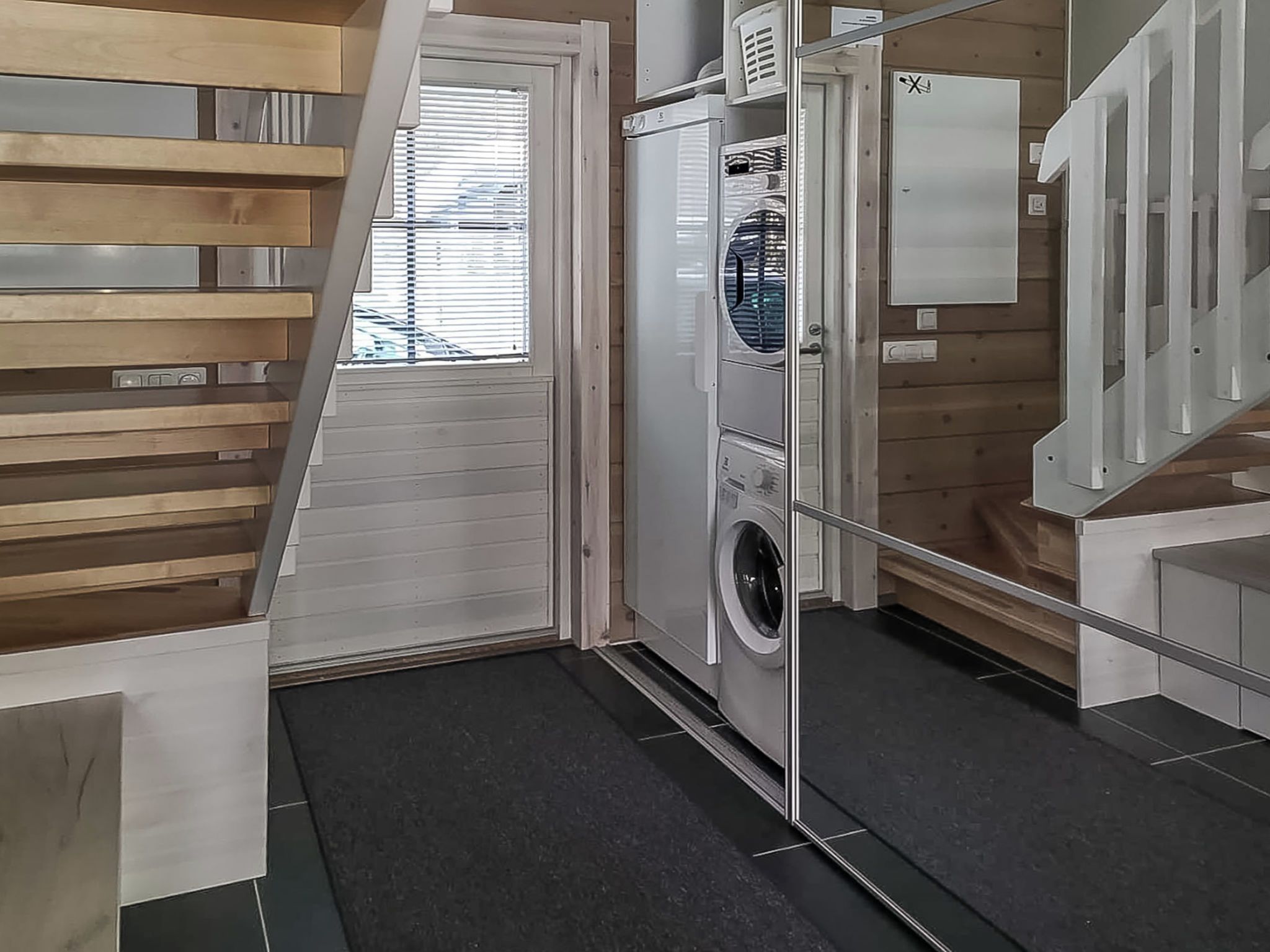 Een wasserette met een wasmachine, droger en gestapelde kastjes.
