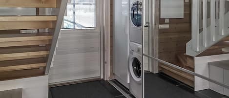 A laundry room with a washing machine, dryer, and stacked cabinets.