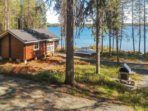 A cabin with a deck overlooking a lake, surrounded by trees. - Ylikitkajärvi, kesäkumpu by Interhome (Kuusamo)
