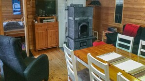 Een gezellig houten interieur met een open haard, een televisie en een eethoek.