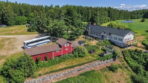 An aerial view of a rural property with a large white house, a red barn, and solar panels. - Aamuntorkku by Interhome (Punkaharju)