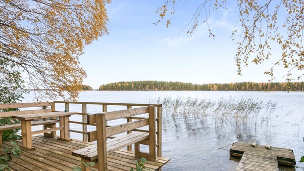 A wooden dock extending into a calm lake with a forested shoreline in the background. - Aamuntorkku by Interhome (Punkaharju)