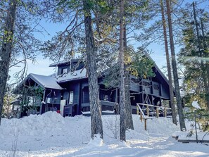 A large, dark wooden cabin surrounded by snow-covered ground and trees. - Utsunusko a by Interhome (Kittilä)