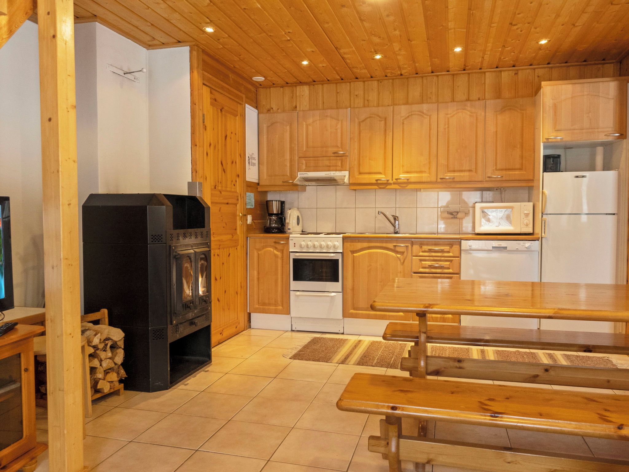 Cocina con armarios de madera, estufa, microondas y refrigerador.