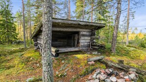 A rustic log cabin surrounded by a forest.