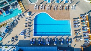 An aerial view of a resort with a large central pool, sun loungers, and a separate smaller pool area. - Harmony Crest Resort& SPA (Kos)