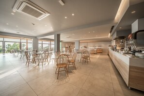 A spacious dining area with high ceilings, large windows, and a modern kitchen visible in the background. - Harmony Crest Resort& SPA (Kos)