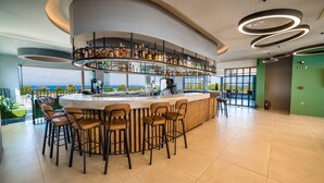 Un bar moderno con un diseño curvo, diversas opciones de asientos y vistas al océano.