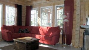 Una sala de estar acogedora con un sofá rojo, una mesa de centro de madera y una chimenea.