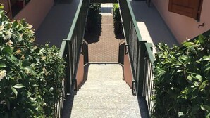 A staircase leading to a terrace with a view of the sea.