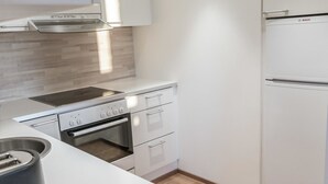 A modern kitchen with a Bosch refrigerator, a built-in oven, and a stovetop.