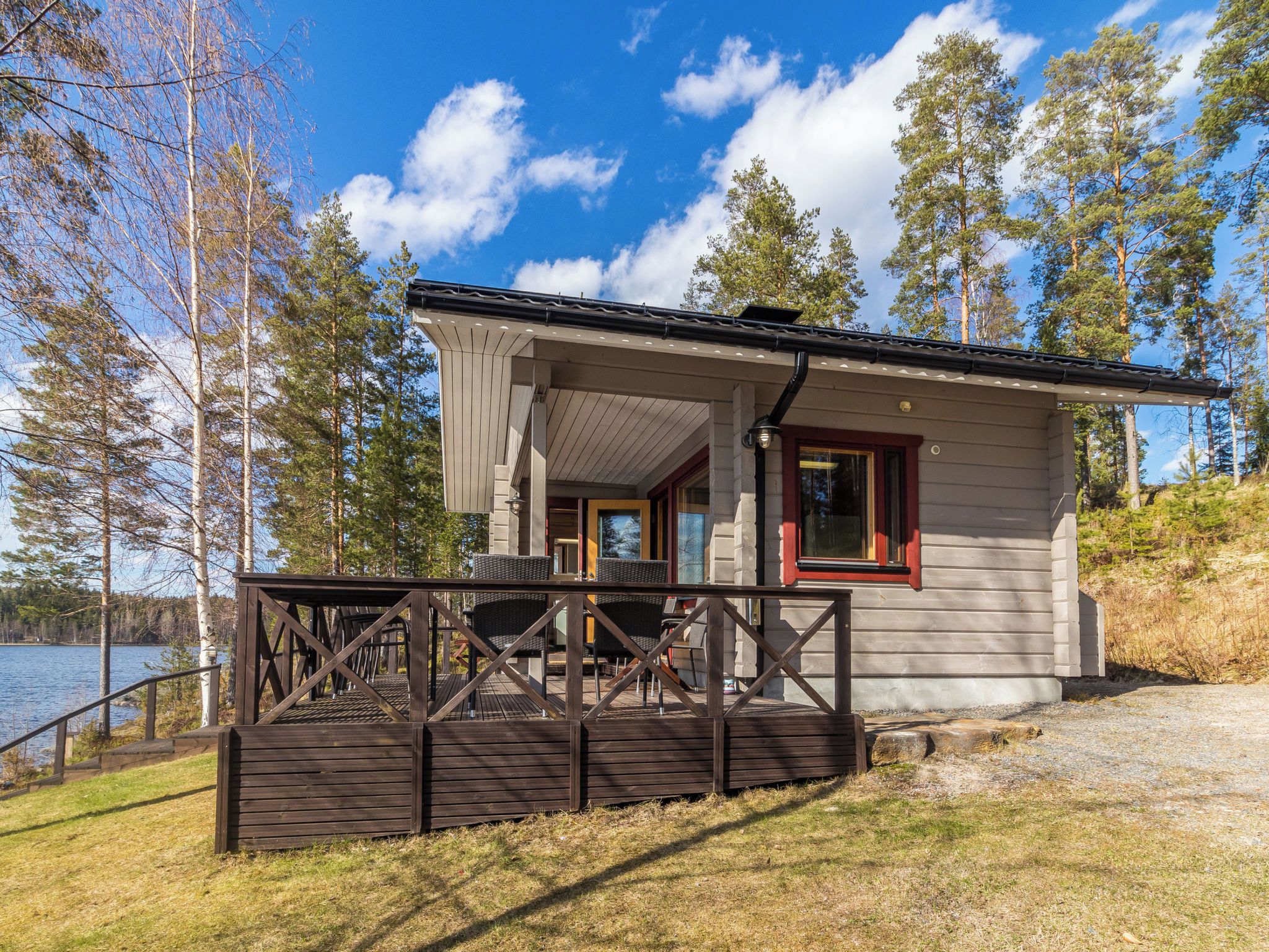 A cabin with a deck, a window, and a door.