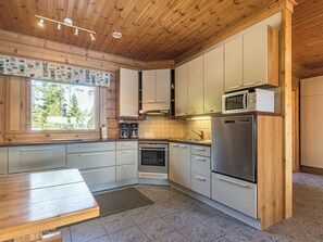 Une cuisine moderne avec des meubles en bois, des appareils électroménagers en acier inoxydable et une grande fenêtre.