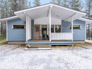 A two-story house with a porch, a front door, and a small set of stairs leading up to the entrance. - Villa valokki by Interhome (Kuusamo)