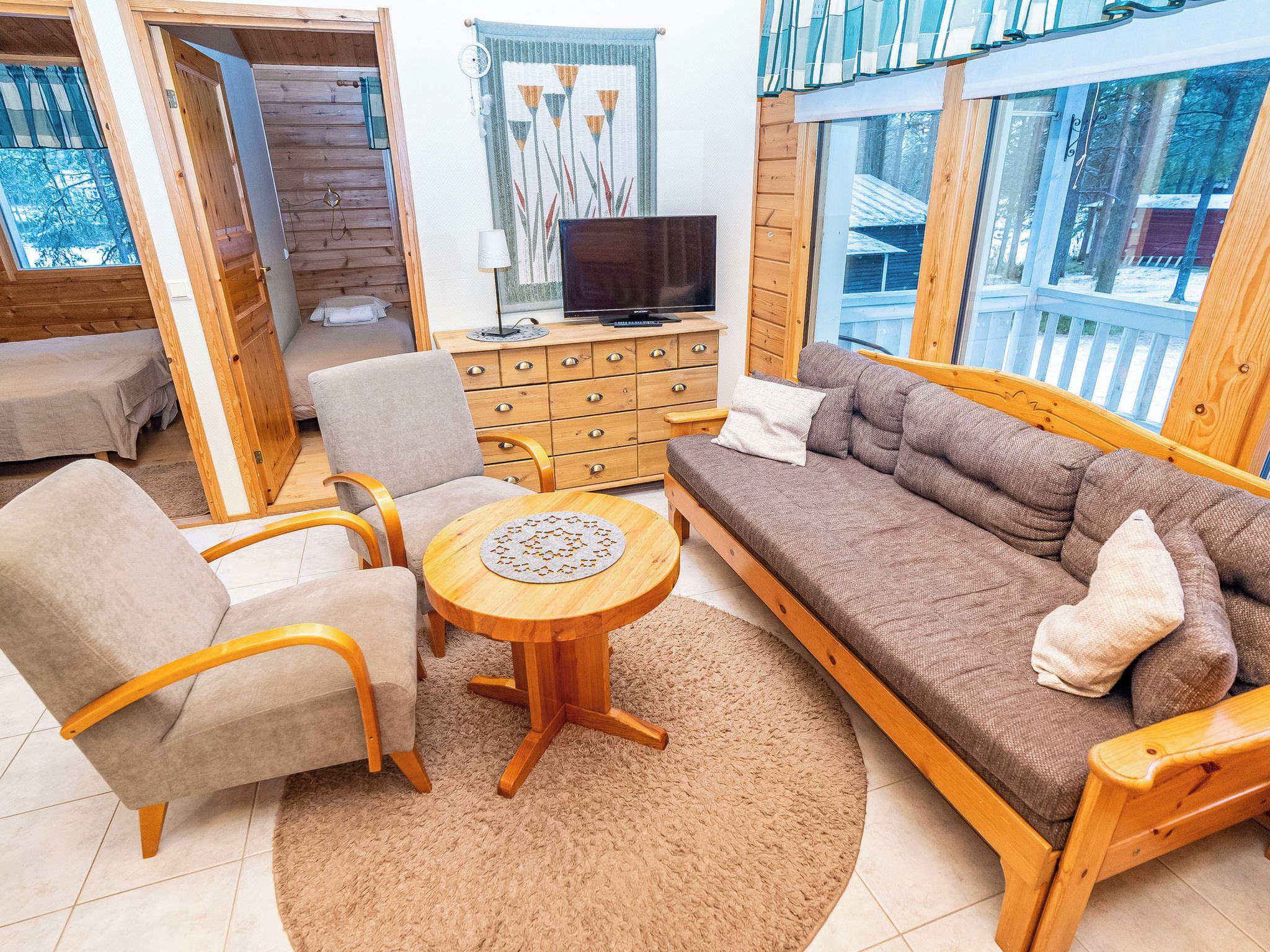 Een gezellige woonkamer met een bank, fauteuils, een salontafel en een televisie.