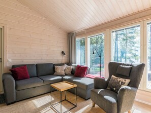 Een moderne woonkamer met een modulaire bank, een fauteuil en een klein bijzettafeltje.