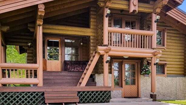 A log cabin with a porch, a staircase, and a door. - Rinne-expertti by Interhome (Ruokolahti)