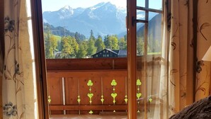 Un dormitorio con vistas a una cordillera a través de una ventana.