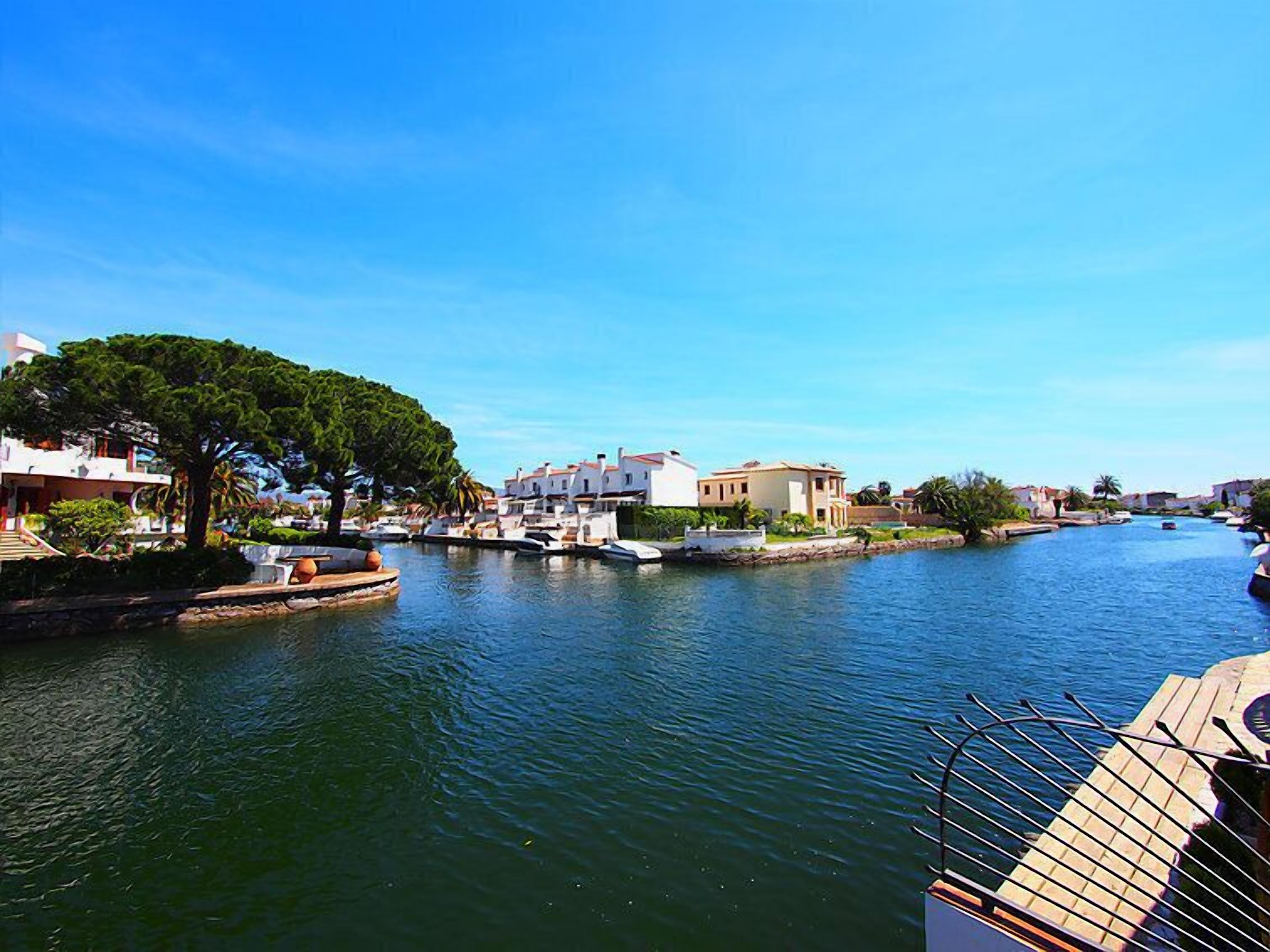 Un canal bordé d’immeubles d’un côté et d’une promenade ombragée par des arbres de l’autre.
