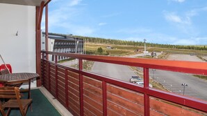 Ein Balkon mit Blick auf einen Parkplatz und Gebäude in der Ferne.
