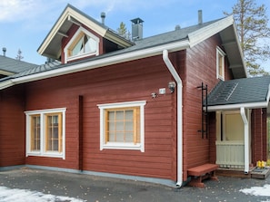 A red wooden house with two windows, a chimney, and a porch. - Levimaa by Interhome (Kittilä)