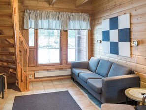 A wooden interior with a sofa, a patterned curtain, a checkered wall, and a staircase. - Levimaa by Interhome (Kittilä)