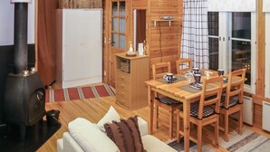 A cozy cabin interior with a dining area, a sofa, a fireplace, and a kitchen area. - Yllästokka 7 by Interhome (Ylläsjärvi)