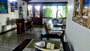 Una habitación con una mesa de comedor, sillas, una pequeña cocina y un ventanal con vistas a zonas verdes.