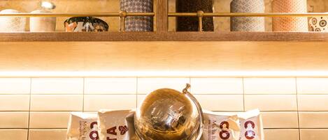 A kitchen shelf with various items including a globe, coffee bags, and patterned containers.