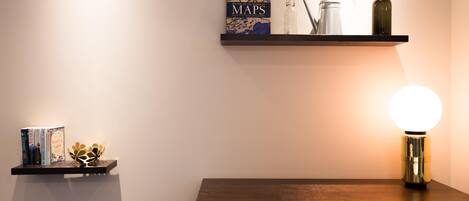 Ein Regal mit Büchern, Dekoration und einer Lampe sowie ein Schrank.