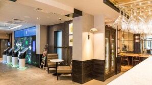 Un moderno vestíbulo de hotel con una recepción, zona de estar y un bar.