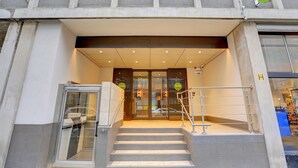 A hotel entrance with a glass door, a staircase, and a sign indicating 'hub by Premier Inn.' - hub by Premier Inn London Tottenham Court Road (Goodge Street) (London)