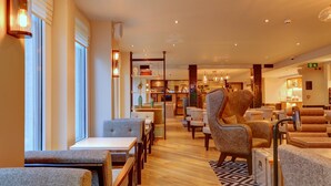 A hotel lobby with seating areas, tables, and a reception desk. - hub by Premier Inn London Tottenham Court Road (Goodge Street) (London)
