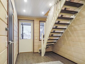 Un intérieur en bois avec un escalier, une porte et une fenêtre.