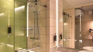 A modern bathroom with a glass shower enclosure, a vanity with a mirror, and a sink. - Hub By Premier Inn London City Bank (London)