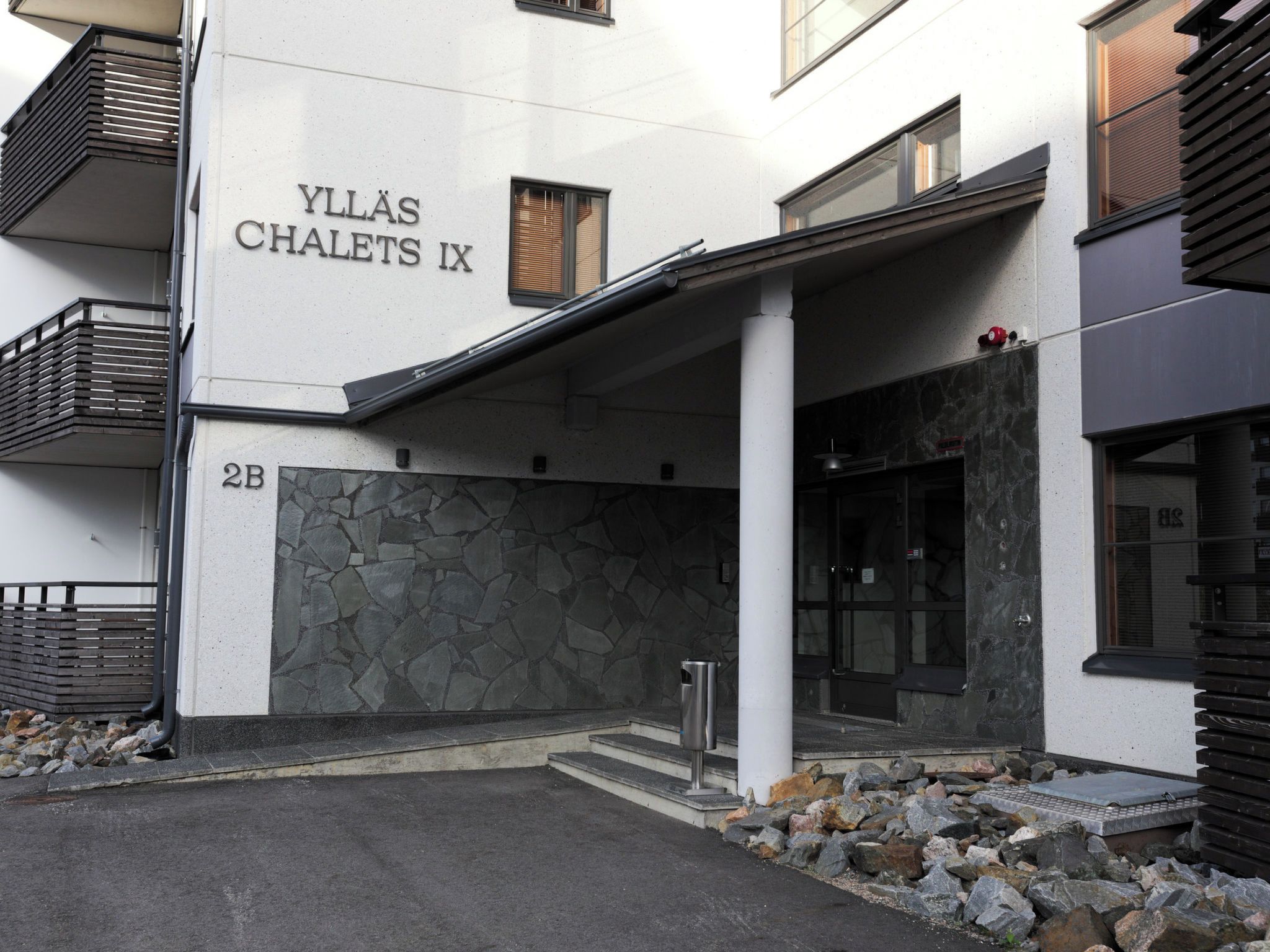 Un edificio con un letrero que dice 'YLLAS CHALETS IX' y fachada de piedra.