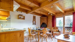 A wooden cabin interior with a kitchen, dining area, and a cozy seating space. - Les Hauts des Chavants - by Interhome (Les Houches)