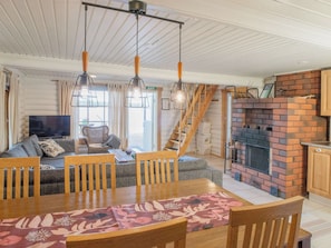 A cozy living room with a sofa, dining table, and a fireplace. - Ranta 2 by Interhome (Asikkala)